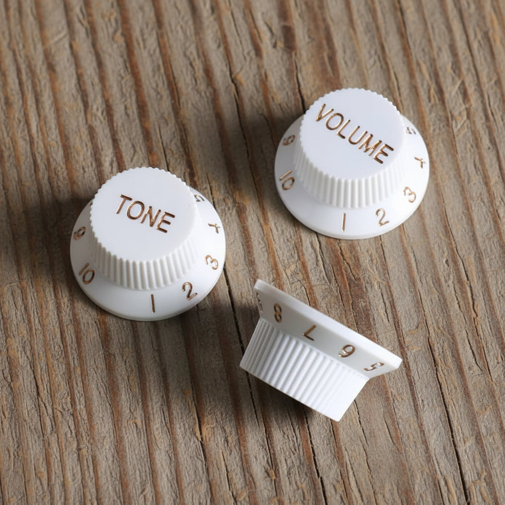 Stratocaster-style volume and tone knob set, cream finish, top view showing numbered skirt