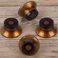 1950s-style amber guitar control knob set, four knobs, numbered 0-10, on workbench